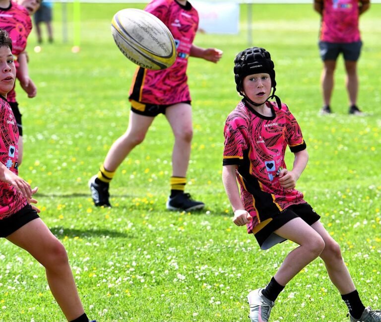 Two Aspatria Hornets juniors in the pink away kit moving the ball during a game