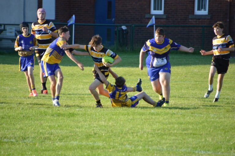 Aspatria Hornets juniors defending against a team in blue and white