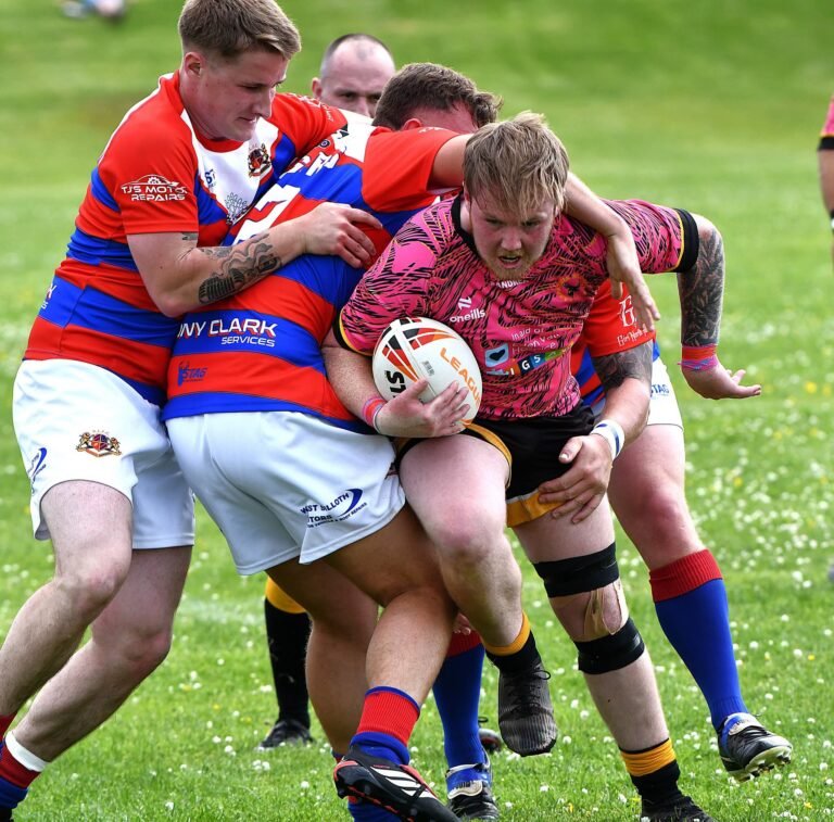 An Aspatria Hornets player brought down in a two man tackle