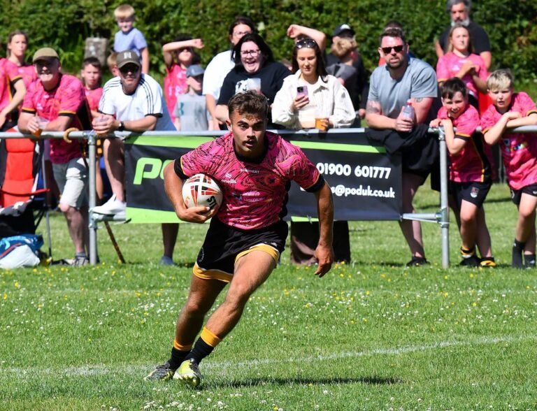 A player carrying the ball back in front of the spectators