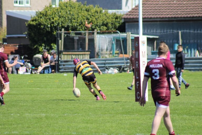 An Aspatria Hornets player kicking downfield